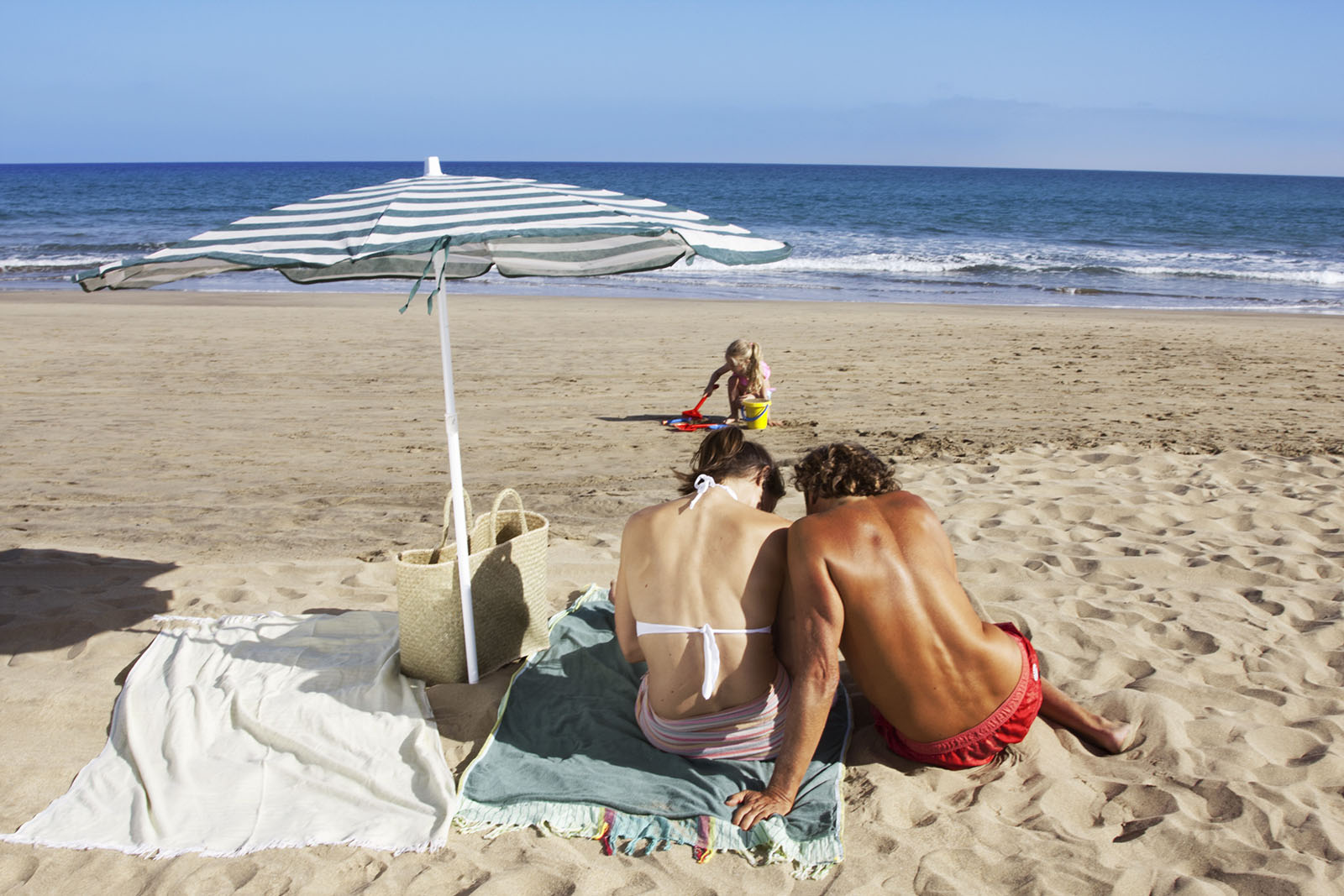 Foto de familia jugando con las olas en la orlla de la playa